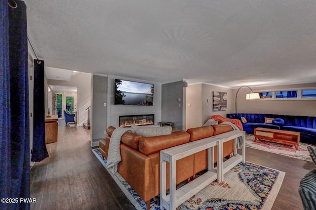 living room featuring wood finished floors and a glass covered fireplace
