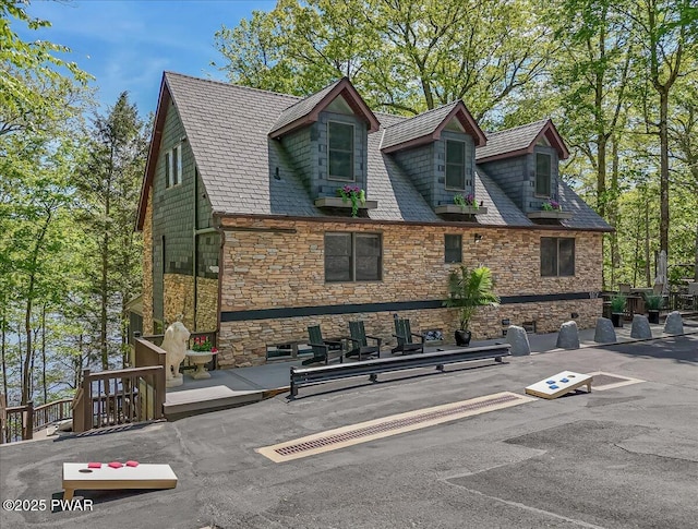view of side of property with stone siding and a high end roof