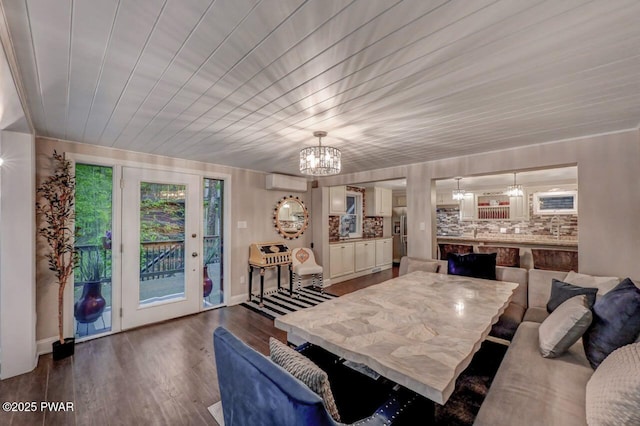 dining room featuring a chandelier, a wall unit AC, dark wood-type flooring, baseboards, and wooden ceiling
