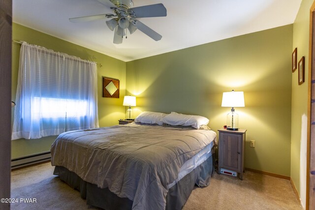 carpeted bedroom with ceiling fan and a baseboard heating unit