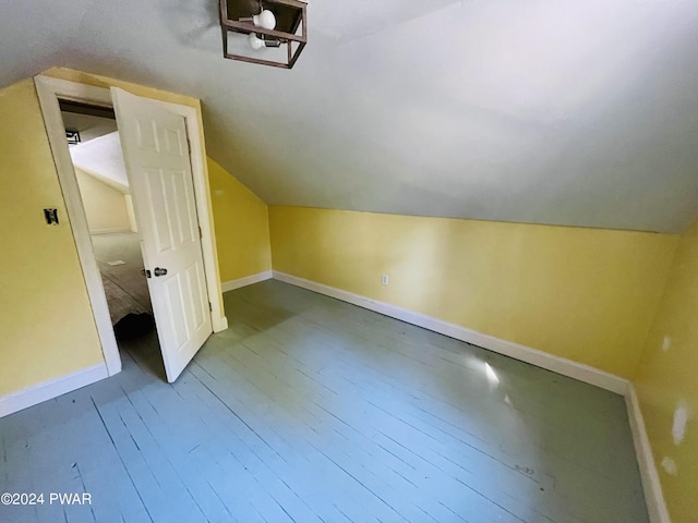 bonus room with hardwood / wood-style floors and vaulted ceiling