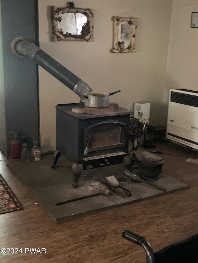 details with hardwood / wood-style floors, a wood stove, and heating unit