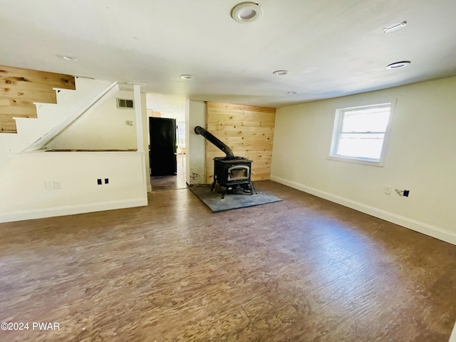 workout area featuring a wood stove and dark wood-type flooring