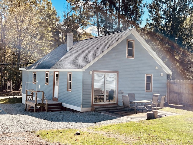 rear view of property featuring a lawn, a patio area, and a deck