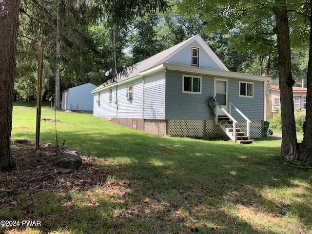 back of property featuring cooling unit and a yard