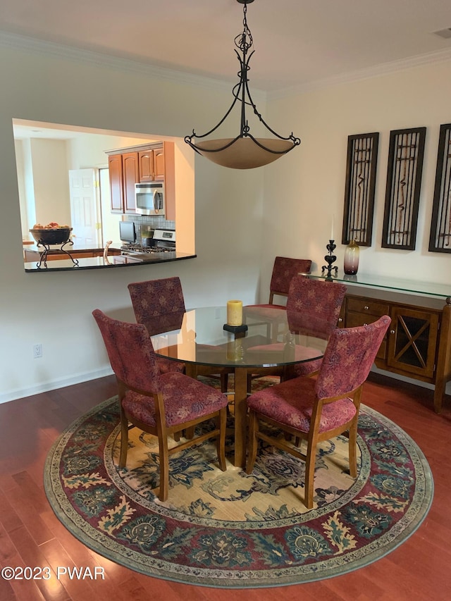 dining room with dark hardwood / wood-style floors and crown molding