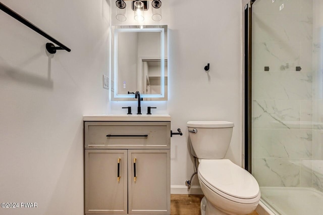 bathroom featuring an enclosed shower, vanity, and toilet