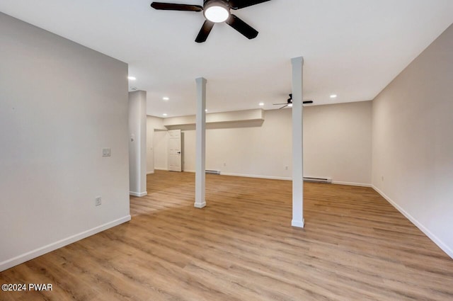 basement with light hardwood / wood-style floors and a baseboard radiator