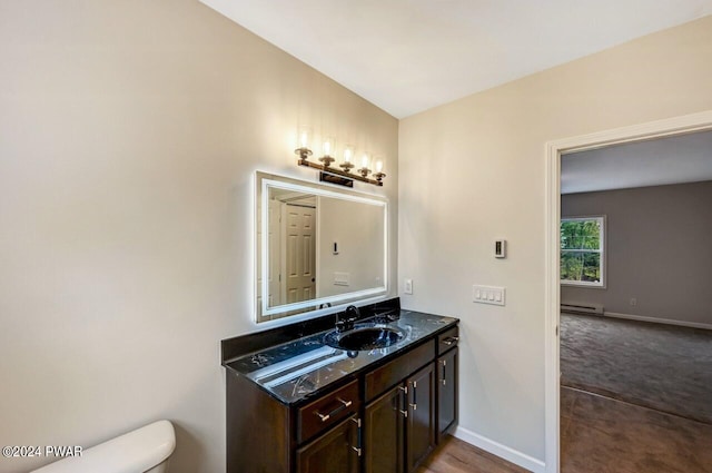 bathroom with vanity, toilet, and a baseboard heating unit