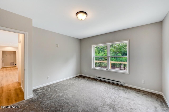 empty room with carpet floors and a baseboard heating unit