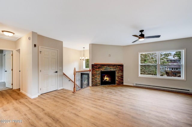 unfurnished living room with ceiling fan with notable chandelier, light hardwood / wood-style floors, a stone fireplace, and baseboard heating