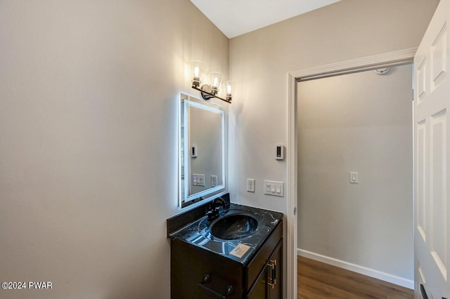 bathroom with vanity, wood-type flooring, and a notable chandelier