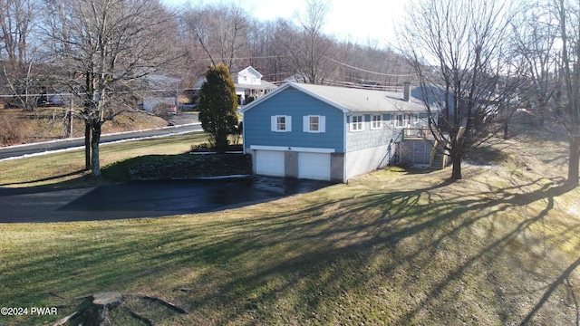 view of side of property featuring a garage and a lawn