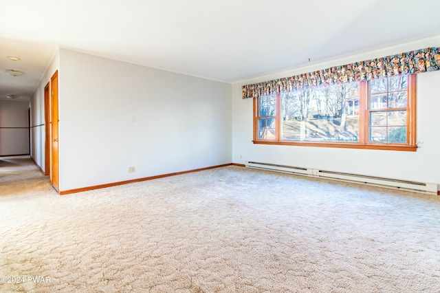 carpeted empty room featuring a healthy amount of sunlight and a baseboard heating unit