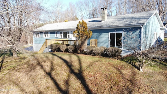 back of house featuring a deck and a yard