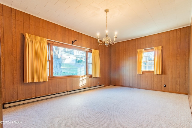 carpeted spare room with wood walls, baseboard heating, and an inviting chandelier