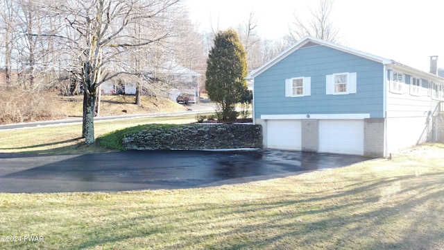 view of home's exterior with a lawn and a garage