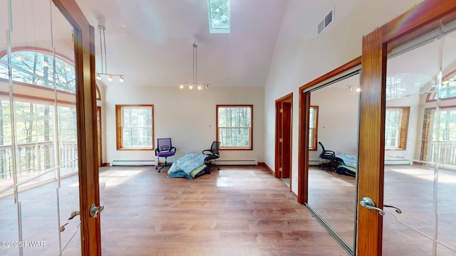 109 Lake Dr, Dingmans Ferry, PA 18328 - entrance foyer with light wood-style floors, high vaulted ceiling, a skylight, a baseboard heating unit, and baseboard heating
