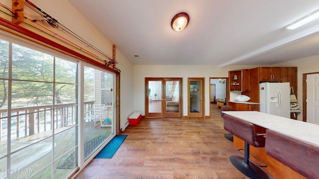 109 Lake Dr, Dingmans Ferry, PA 18328 - kitchen featuring white fridge with ice dispenser, brown cabinetry, light wood-style flooring, light countertops, and french doors