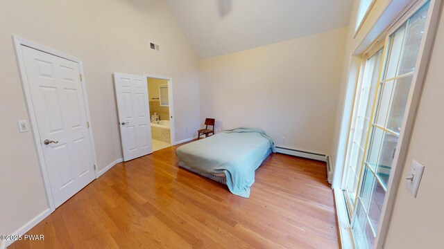 109 Lake Dr, Dingmans Ferry, PA 18328 - bedroom with light wood-type flooring, high vaulted ceiling, baseboard heating, and connected bathroom