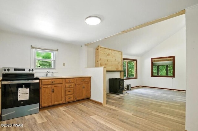 36 Rolling Acres Rd, Lake Ariel, PA 18436 - kitchen with stainless steel range with electric cooktop, a wood stove, plenty of natural light, light wood-style flooring, and vaulted ceiling
