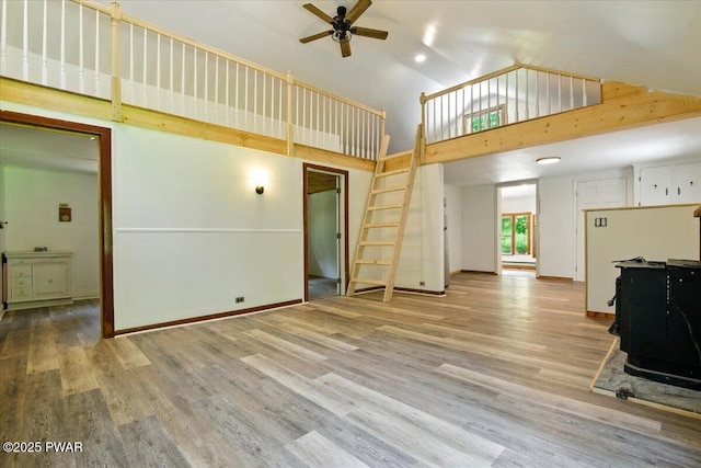 36 Rolling Acres Rd, Lake Ariel, PA 18436 - unfurnished living room with a ceiling fan, a wood stove, wood finished floors, and high vaulted ceiling