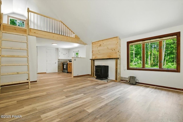 36 Rolling Acres Rd, Lake Ariel, PA 18436 - unfurnished living room with a wood stove, plenty of natural light, high vaulted ceiling, and light wood-style floors