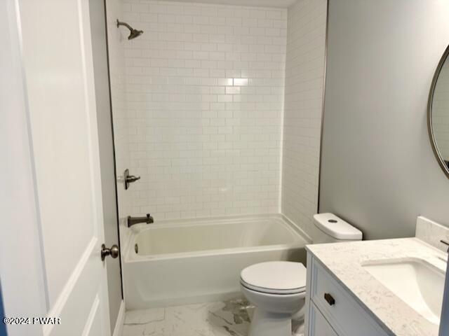 full bathroom with vanity, tiled shower / bath combo, and toilet