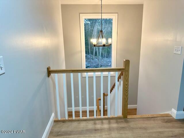 staircase with an inviting chandelier