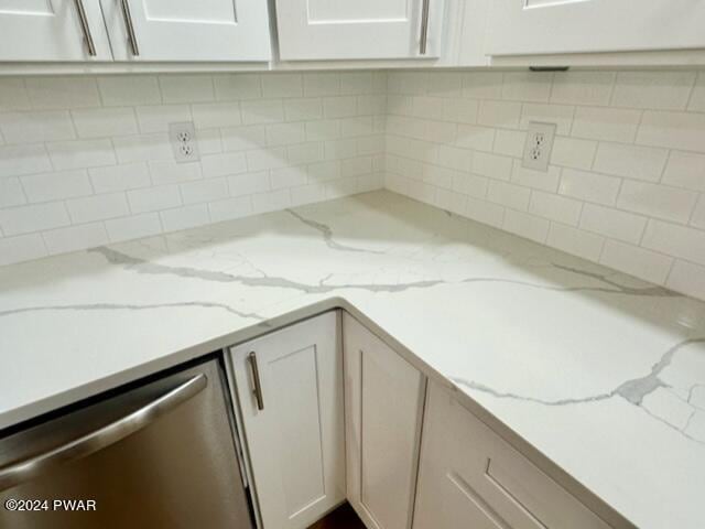 kitchen with white cabinets, dishwasher, light stone counters, and tasteful backsplash