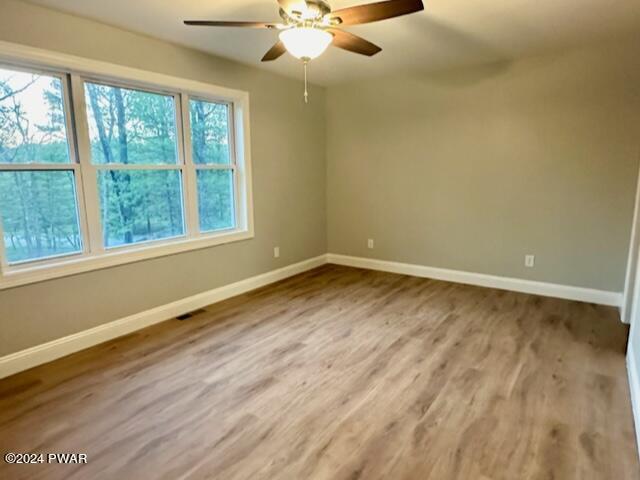 spare room with ceiling fan and wood-type flooring