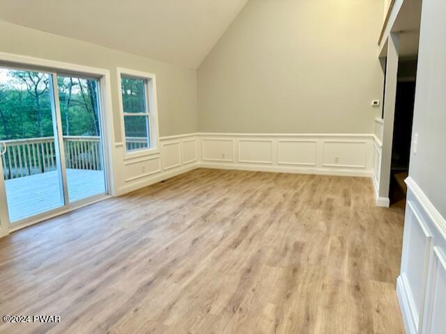 interior space featuring light hardwood / wood-style floors and lofted ceiling