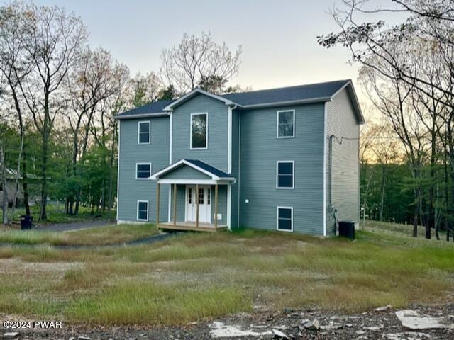 back house at dusk featuring central AC unit