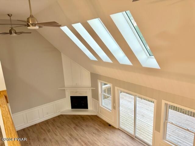 unfurnished living room featuring ceiling fan, a large fireplace, and vaulted ceiling