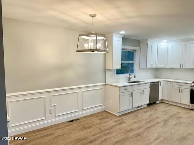 kitchen featuring white cabinetry, sink, hanging light fixtures, and appliances with stainless steel finishes