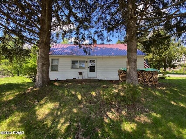 rear view of house featuring a yard