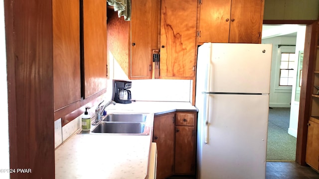 kitchen featuring white fridge, dark carpet, and sink