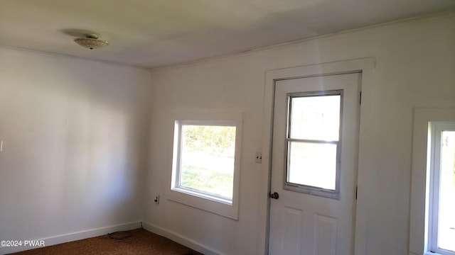 entryway featuring carpet flooring and ornamental molding