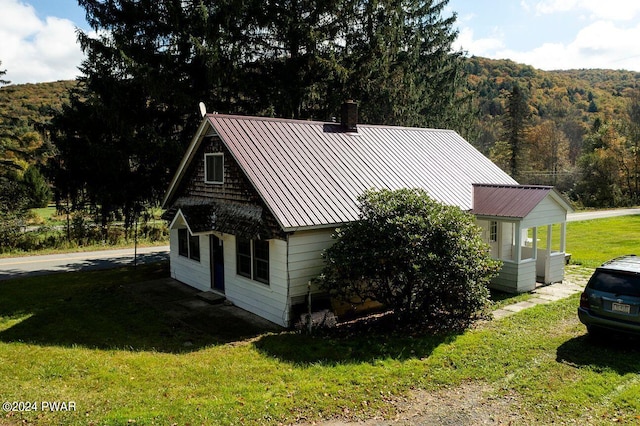 view of side of home with a lawn and a mountain view