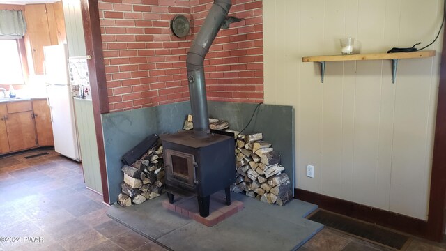 room details with white fridge and a wood stove