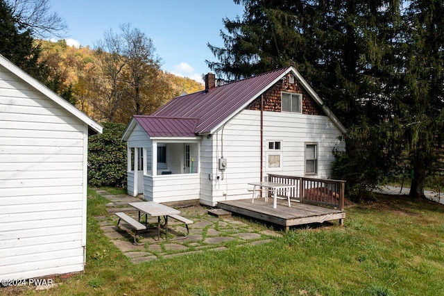 rear view of house with a deck and a yard