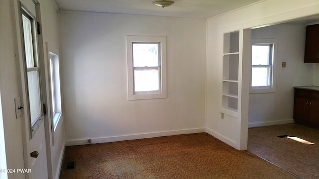 empty room with a healthy amount of sunlight and carpet floors