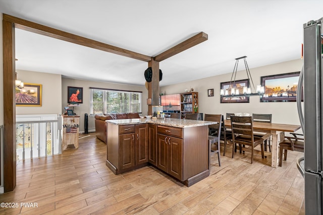 414 Leisure Loop, Milford, PA 18337 - kitchen featuring a chandelier, open floor plan, freestanding refrigerator, light wood finished floors, and beam ceiling