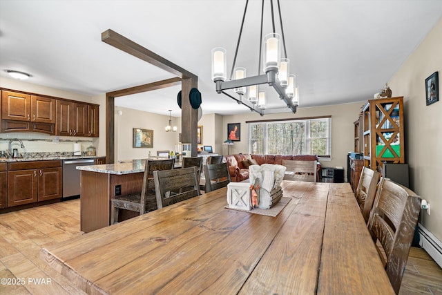 dining space featuring a chandelier, light wood-style floors, and a baseboard radiator