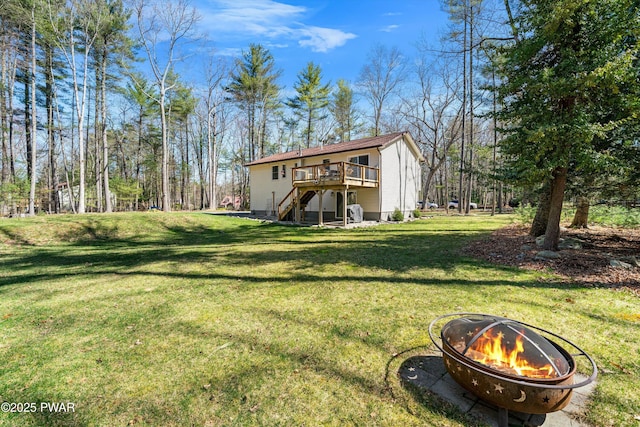 back of property featuring a lawn, stairs, a deck, and an outdoor fire pit