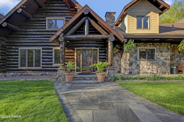 view of front of home featuring log exterior, stone siding, and a front yard