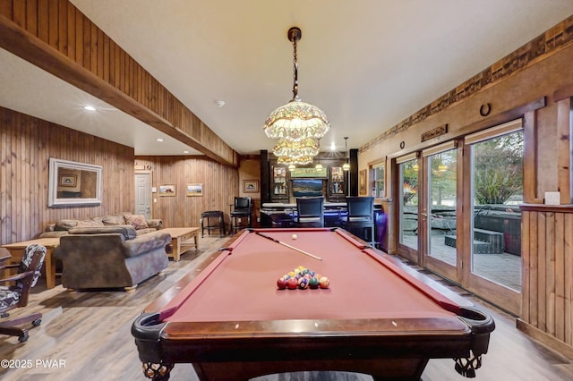 rec room with wooden walls, pool table, an inviting chandelier, and wood finished floors