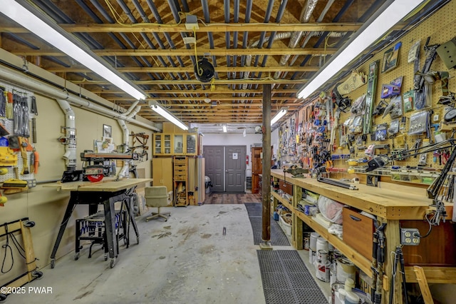 miscellaneous room with concrete flooring and a workshop area