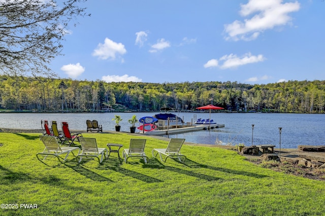 dock area featuring a lawn, a water view, and a view of trees