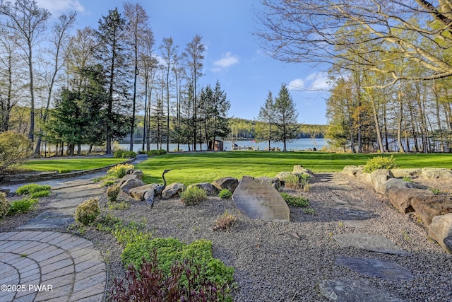 view of property's community featuring a lawn and a water view